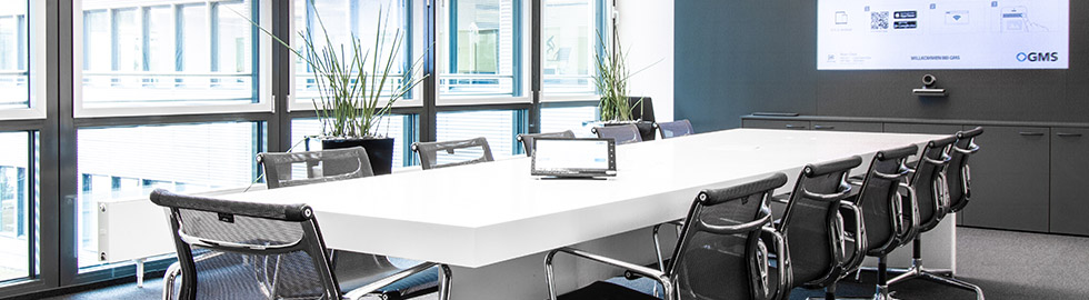 Ein Konferenzraum mit einem langen Tisch und Stühlen.