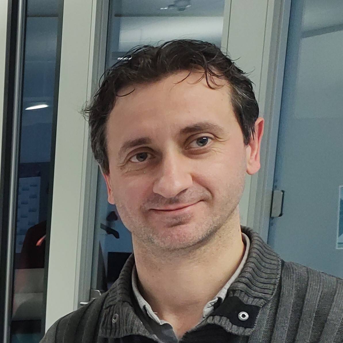 Ein Mann steht vor einer Glastür.